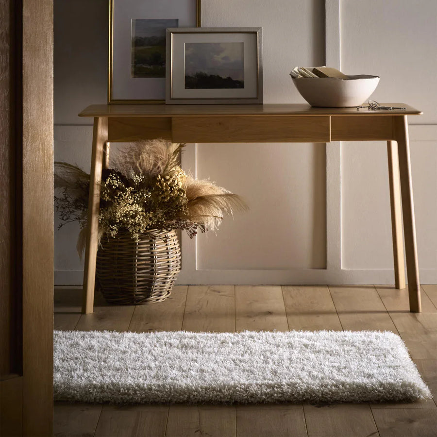 Cream shaggy rug in hallway under console table