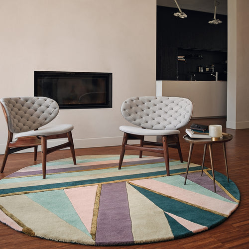 Ted Baker Sahara Pink Round Rug in modern room with two chairs 