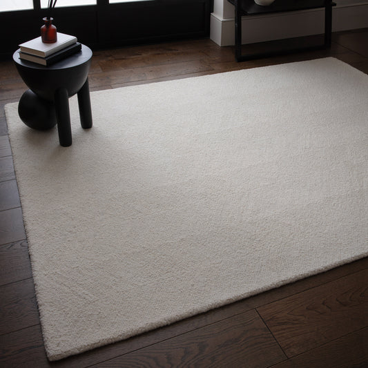 Theodore Chevron Ivory Rug under a small black circular coffee table